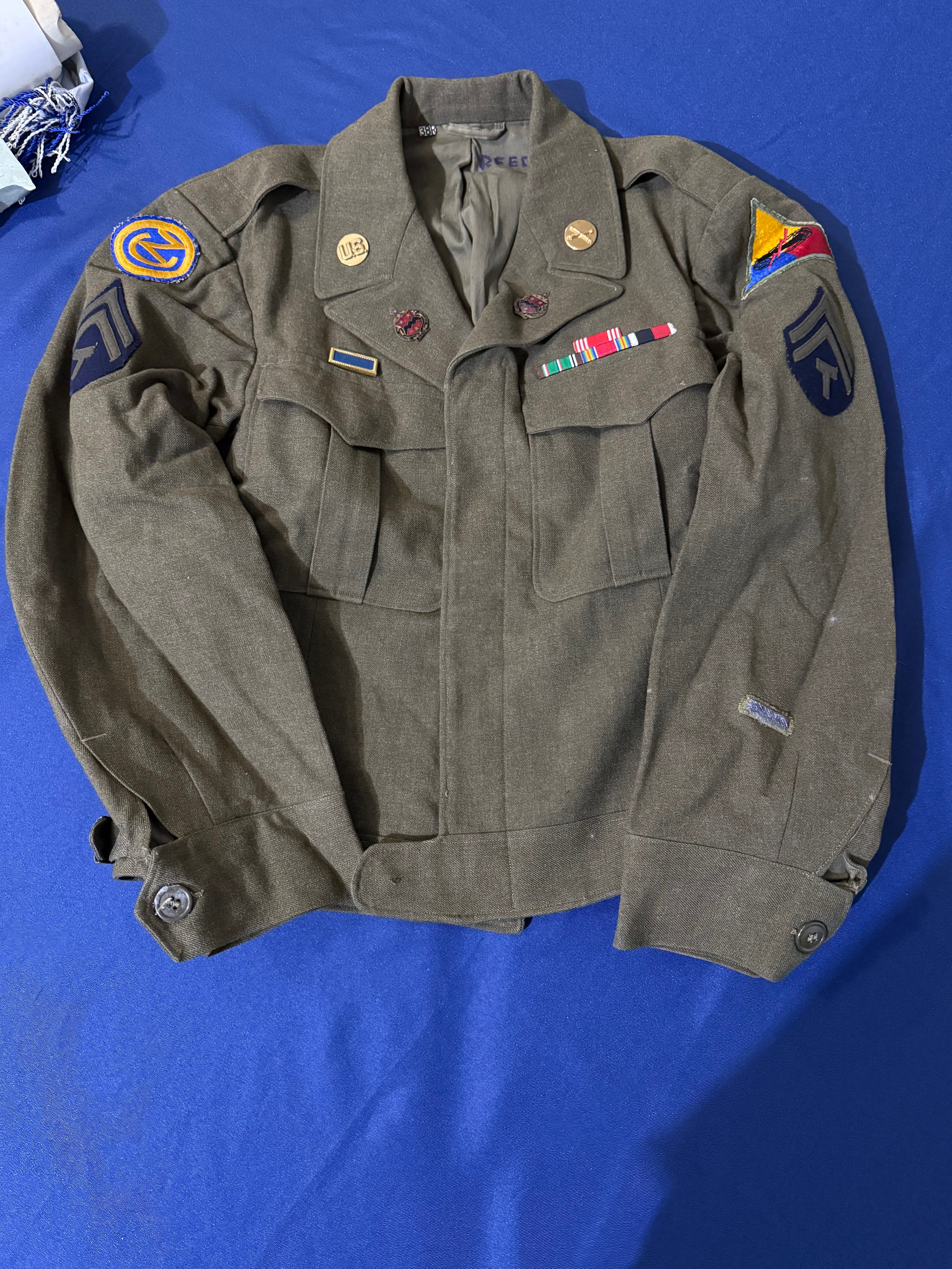 Original WWII U.S. Army uniform grouping attributed to John Reed, who served with the 16th Armored Field Artillery Battalion of the 9th Armored Division and later associated with the 102nd Infantry Division, known as the “Ozark” Division.